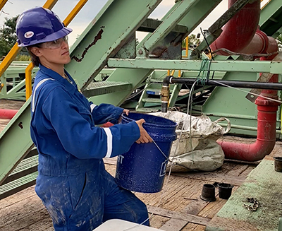 Assistant Professor Nicole Fernandez with a bucket of water collected from the CUBO borehole during the final hydrological test.