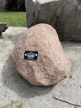 Large rounded pinkish rock with a black tag attached.